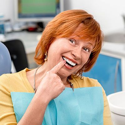 Senior woman pointing to teeth