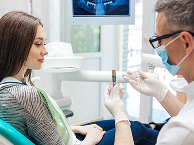 Dentist showing patient dental implant model