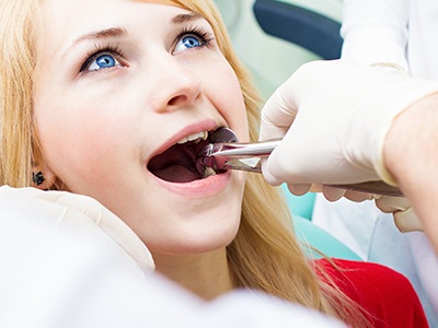 Woman having tooth removed