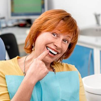 Senior woman pointing to teeth