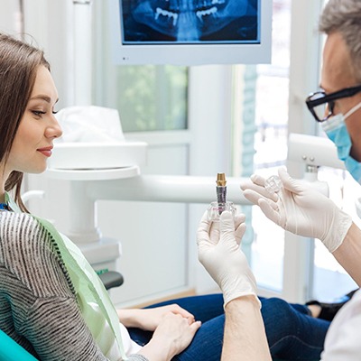 Dentist showing patient implant model