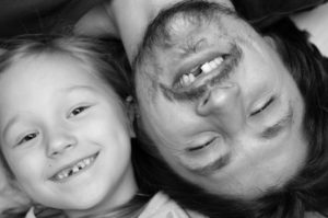 Father and daughter smiling with missing teeth