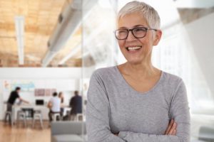 an older woman smiling and showing off her teeth in a day