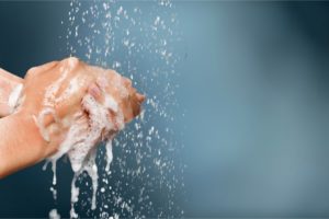 an implant dentist in Tysons, VA, using soap and water to keep their hands clean